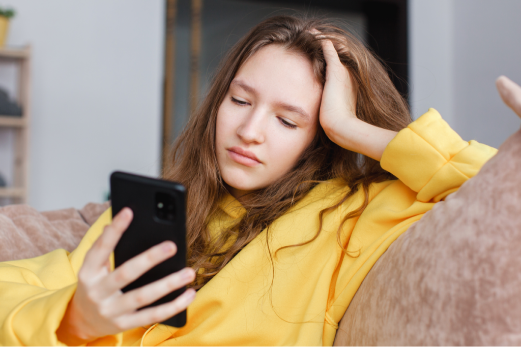 Bekymret tenåring ser på mobilen