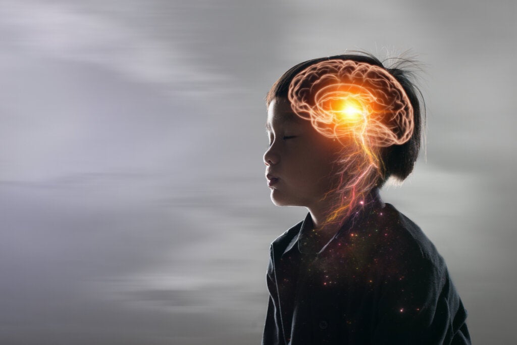 Cerebro del niño iluminado simbolizando la trauma de apego y autocrítica