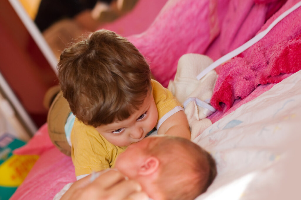 Hermano mayor mirando a su hermano bebé