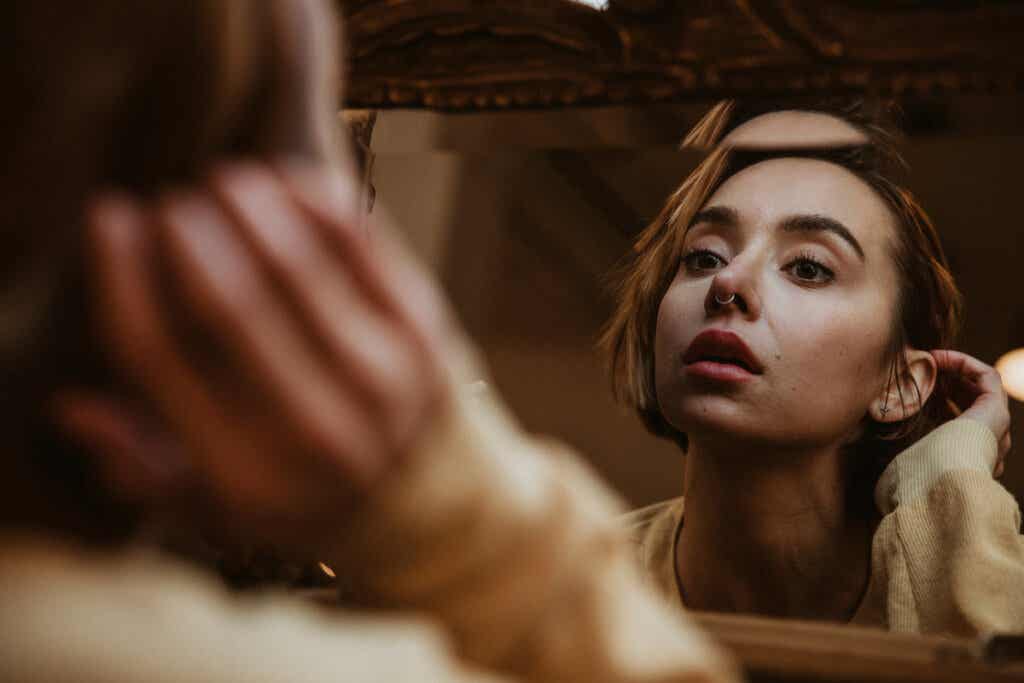 Femme regardant dans le miroir pour représenter le modèle cognitivo-comportemental