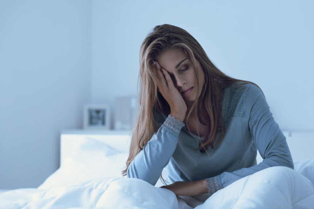 Sad woman in bed thinking about the emotions that weaken your immune system