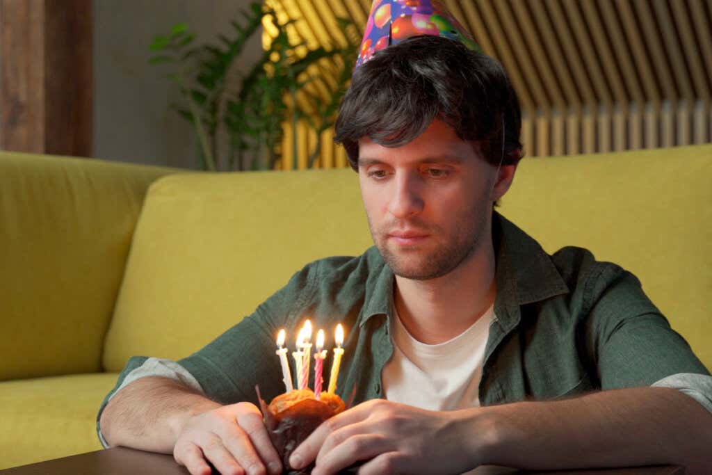 Homem triste comemorando aniversário sofrendo efeito bumerangue de felicidade