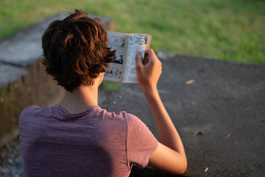 Jeune homme lisant une bande dessinée