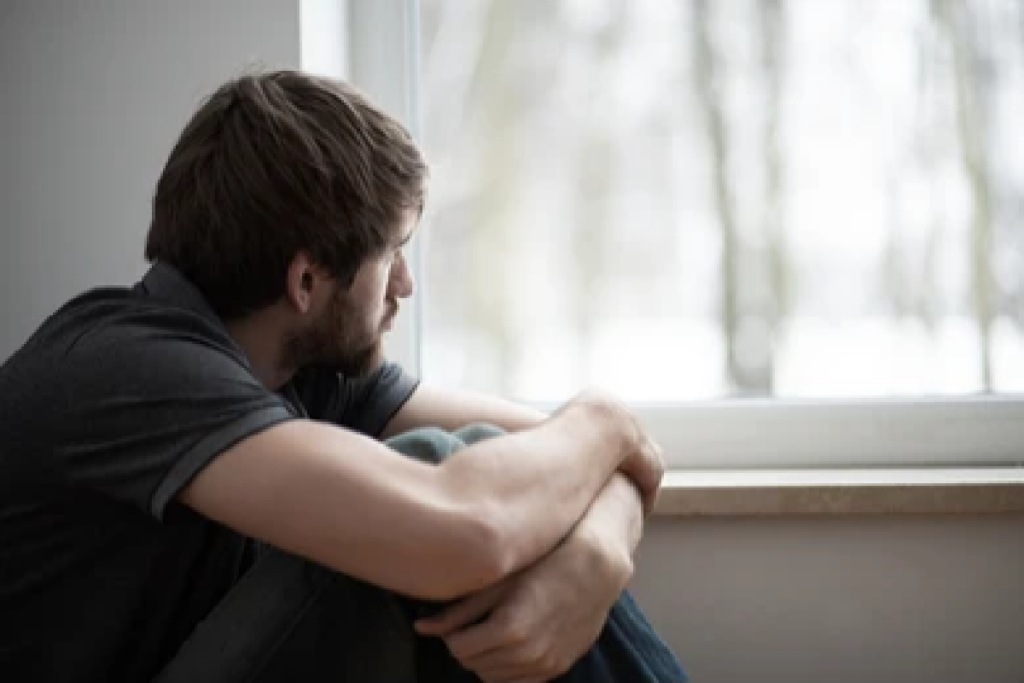 man looking out window