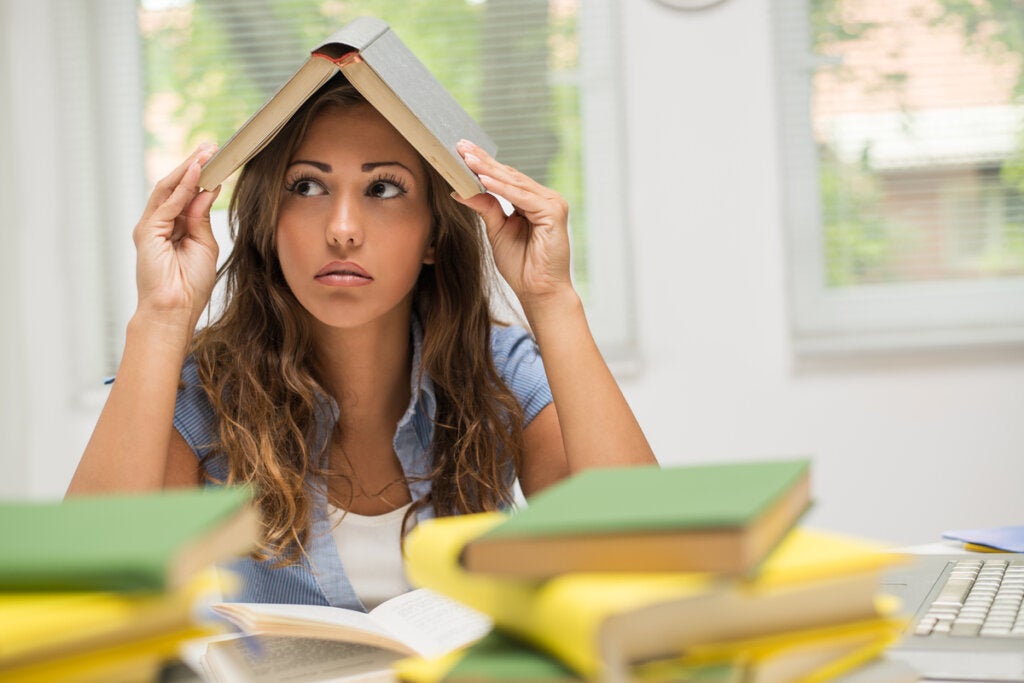 Mujer aburrida con un libro en la cabeza