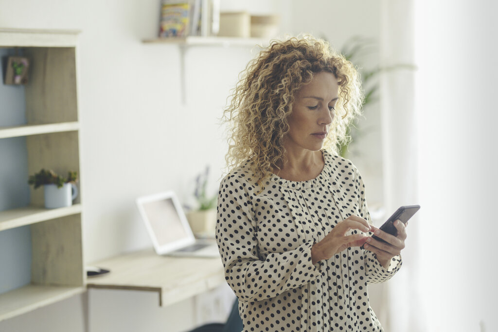 Femme tapant sur mobile pour représenter le syndrome de l'objet brillant