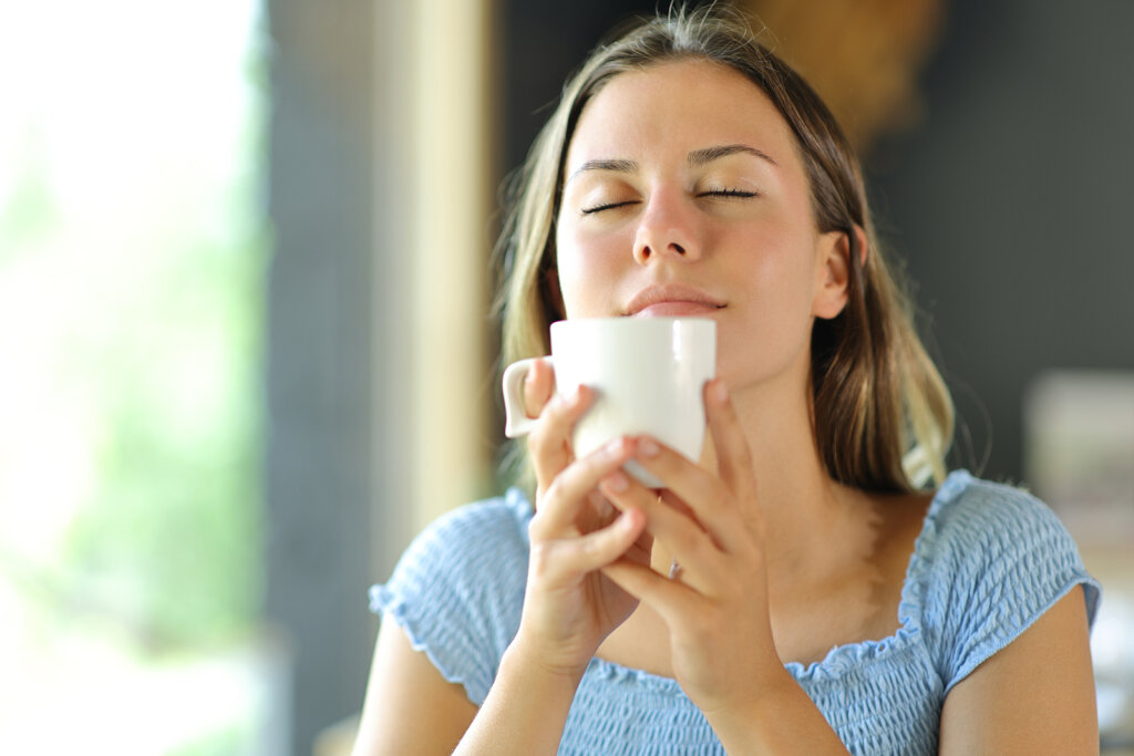 Vrouw ruikt genietend aan haar koffie