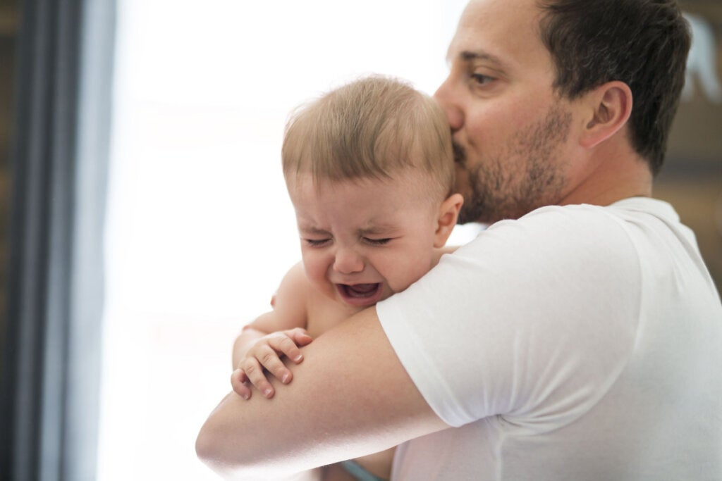Padre calmando a un bebé simbolizando el impacto del estrés paterno