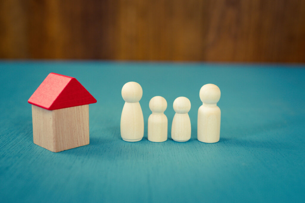 Wooden block house with a red triangle roof next to figures to symbolize how to deal with a toxic family
