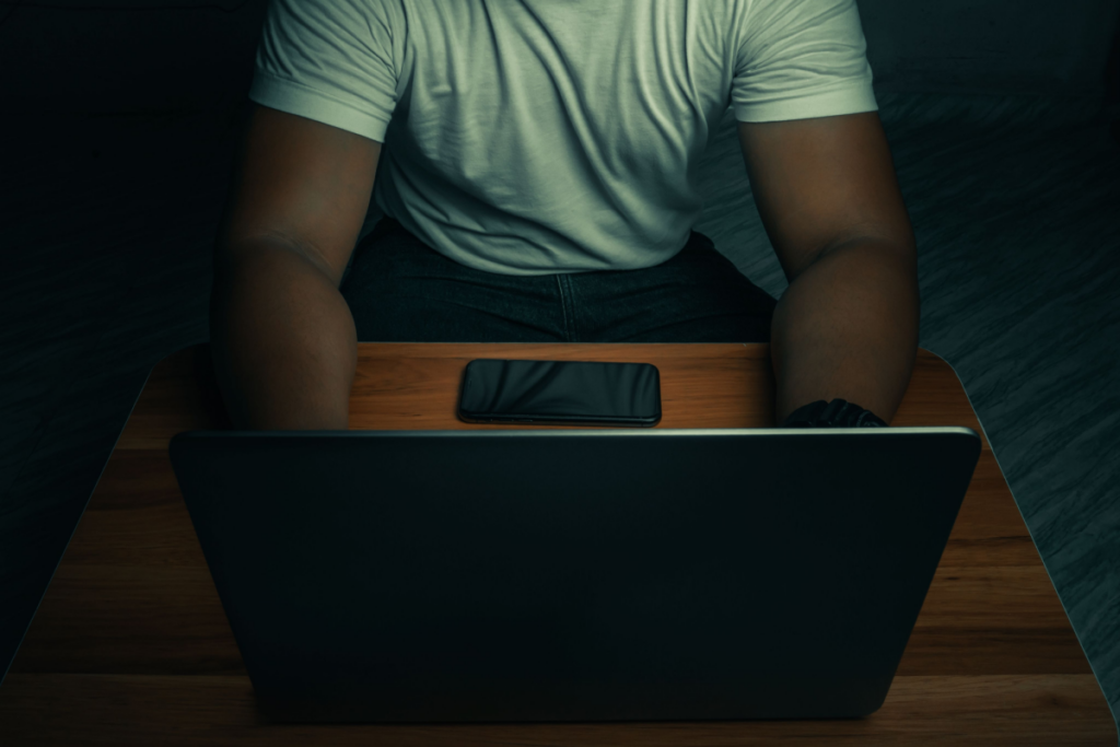 Mann med en datamaskin om natten