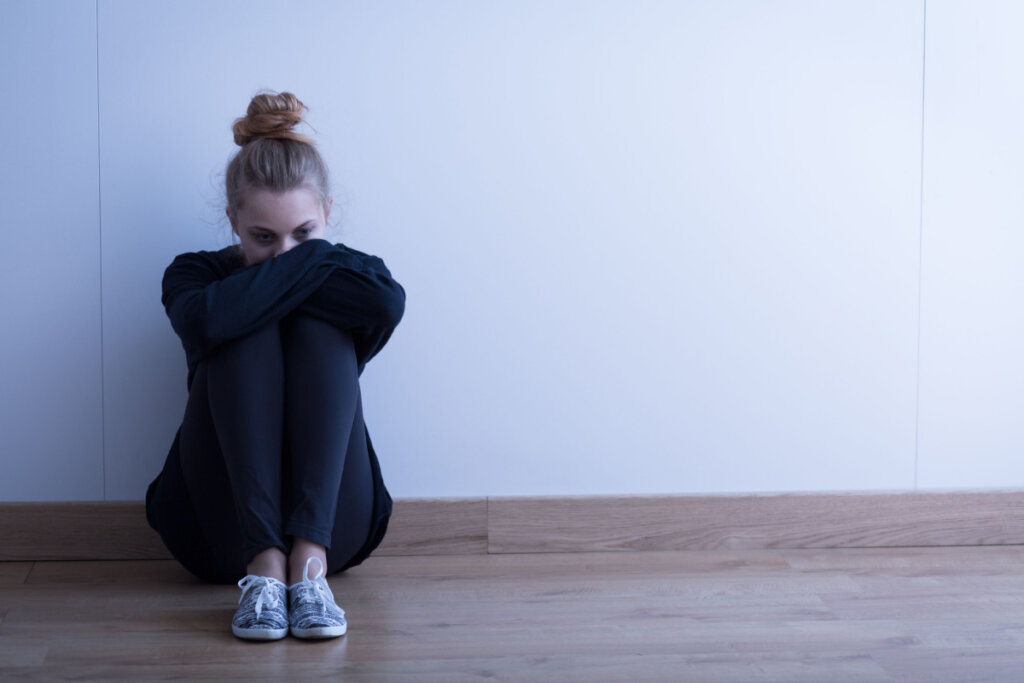 Menina com anorexia sentada no chão