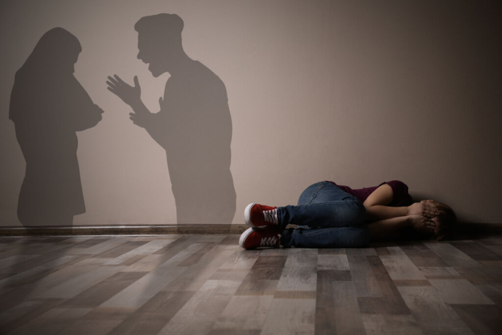 Son suffering while his parents argue symbolizing the theory of emotional security