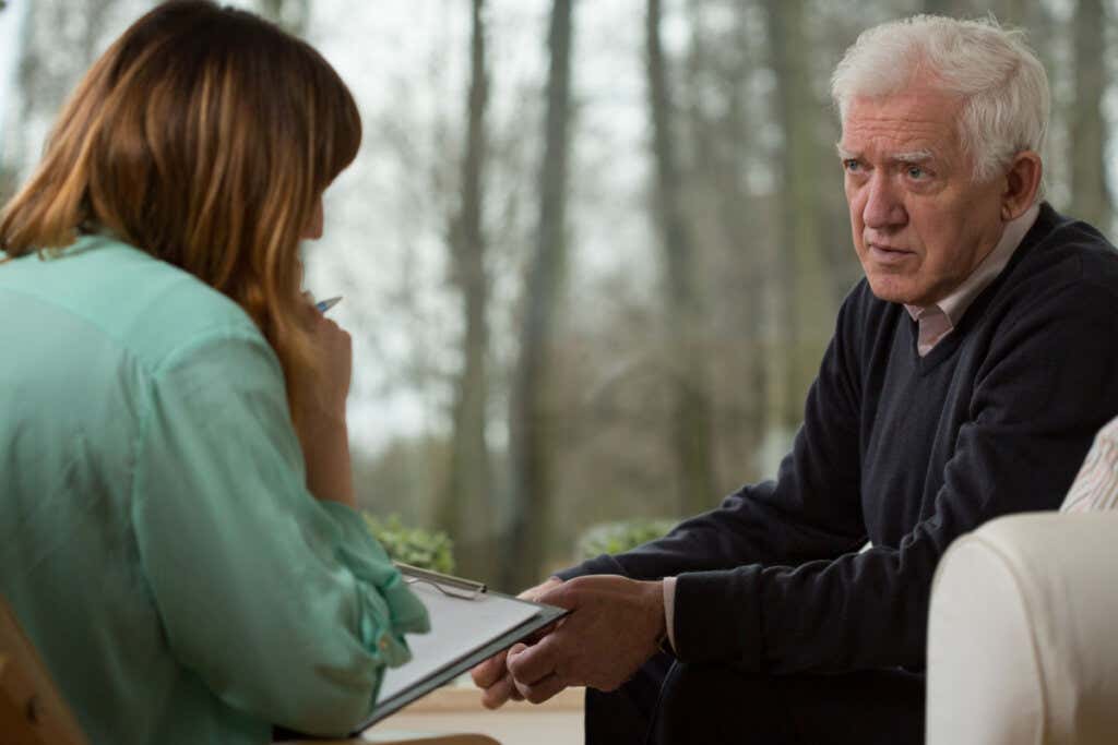 Starszy mężczyzna w terapii z psychologiem informujący go o tym, jak media powinny informować o zdrowiu psychicznym