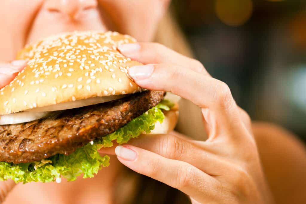 donna che mangia hamburger