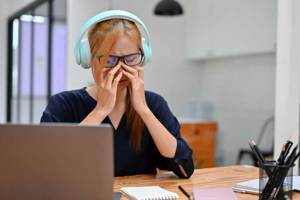 Mujer llorando escuchando música en la oficina