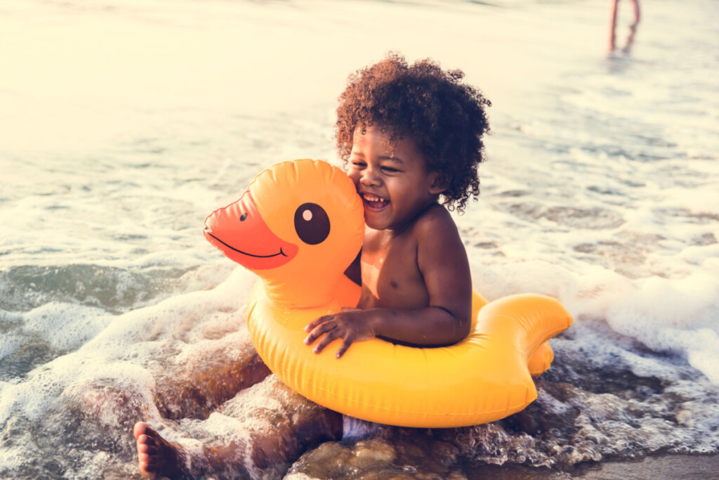 Garçon africain avec un flotteur en mer