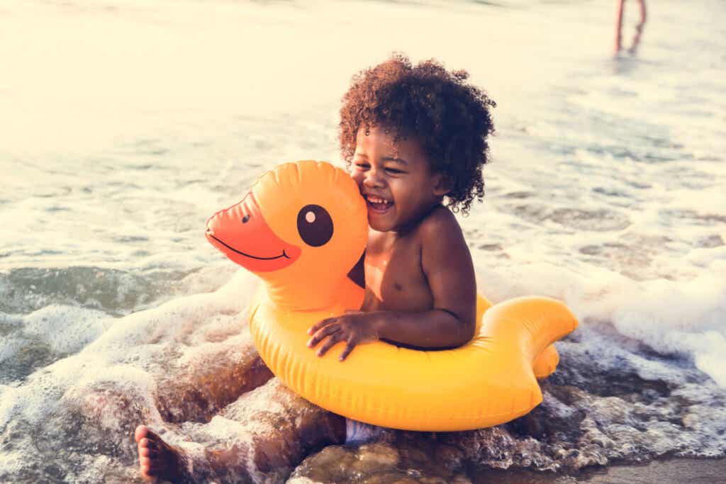 Niño africano con un flotador en el mar