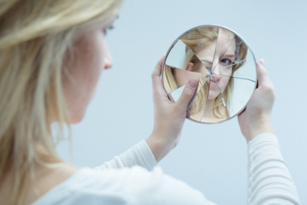 Fille regardant dans un miroir brisé