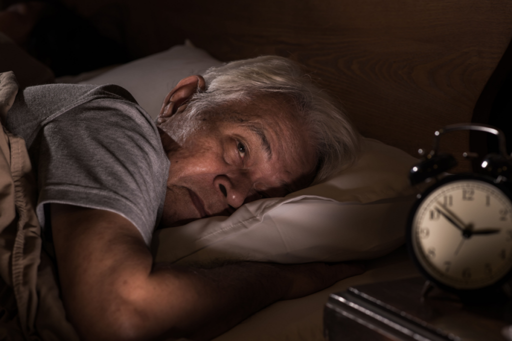 Senior homme éveillé au lit