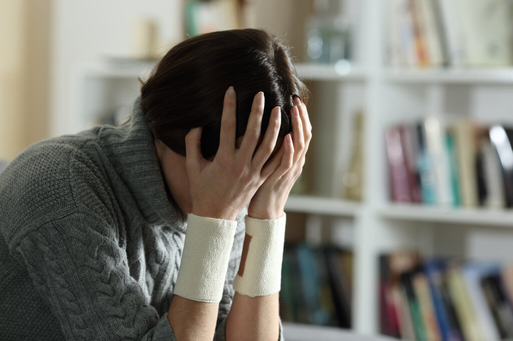 Teenager with bandages on his wrists for attempted suicide