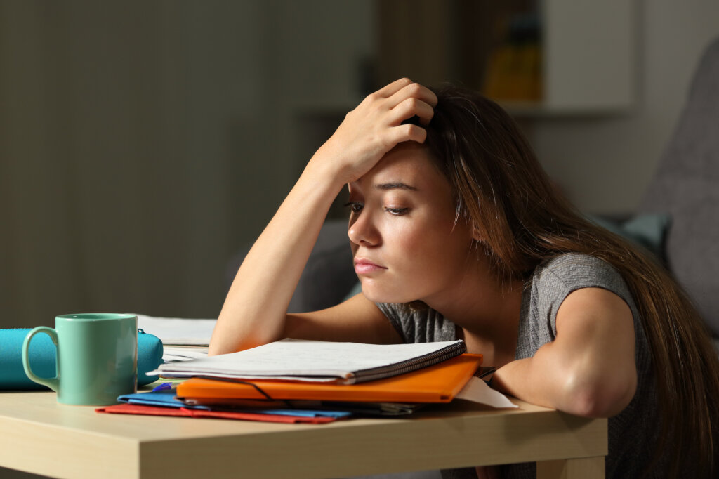 Adolescente somnolente à une table d'étude