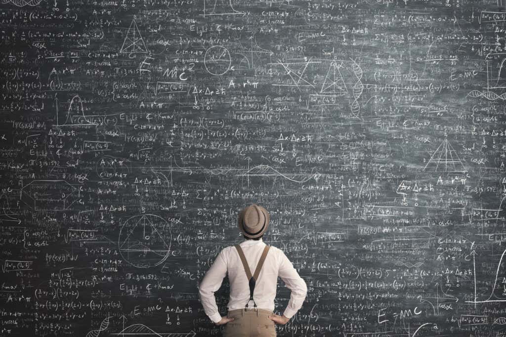 Homem olhando para o quadro com cálculos matemáticos