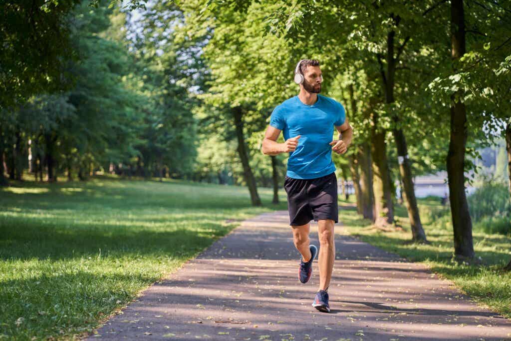 Man exercises by jogging in the park while listening to music