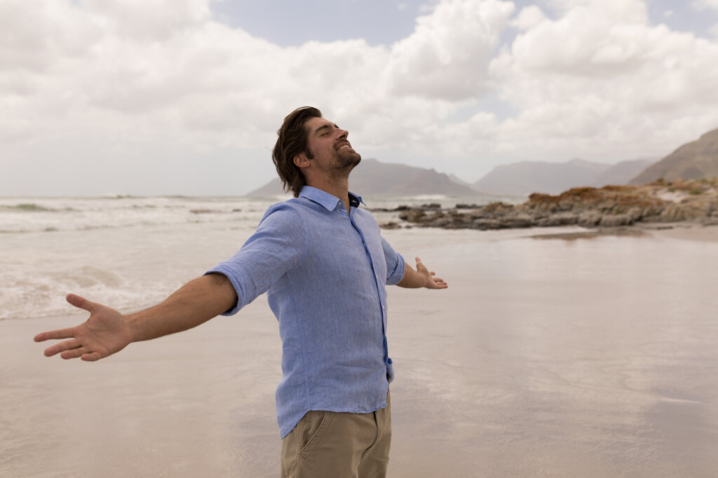 Homme à bras ouverts sur la plage