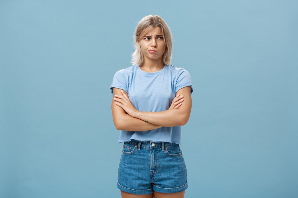 Doubtful young woman on blue background