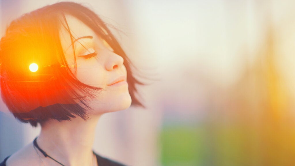 Photograph of a young woman thinking and the sun reflecting on her hair