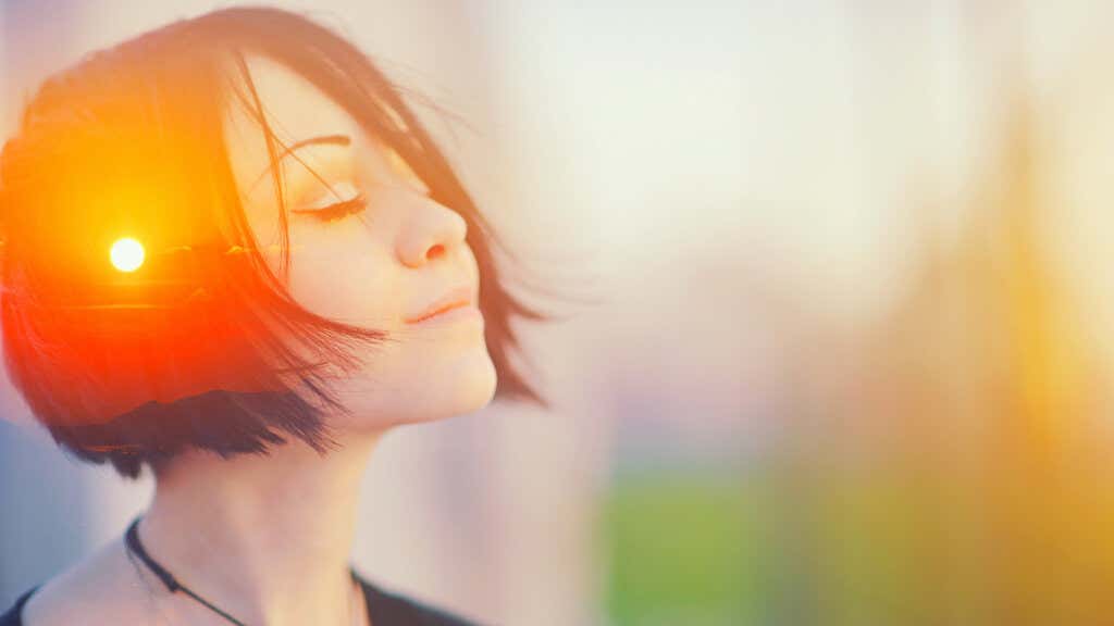 Zdjęcie młodej kobiety myślącej i słońca odbijającego się w jej włosach