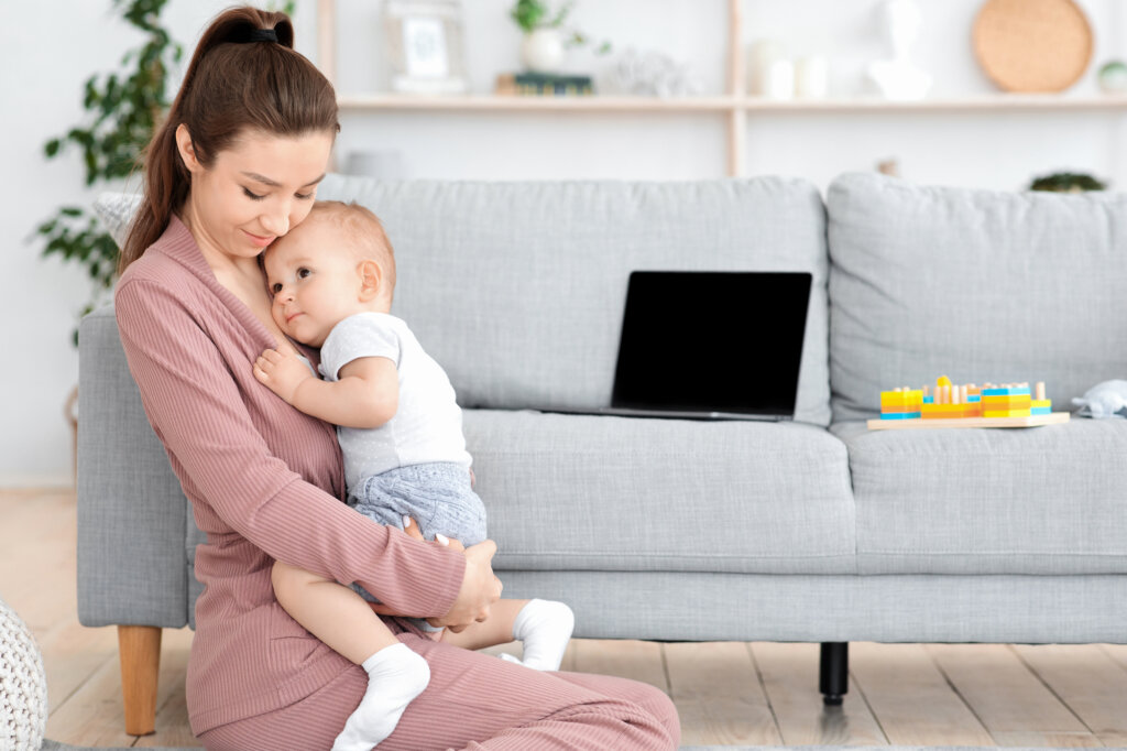 La mère porte son petit fils sur ses genoux dans le salon