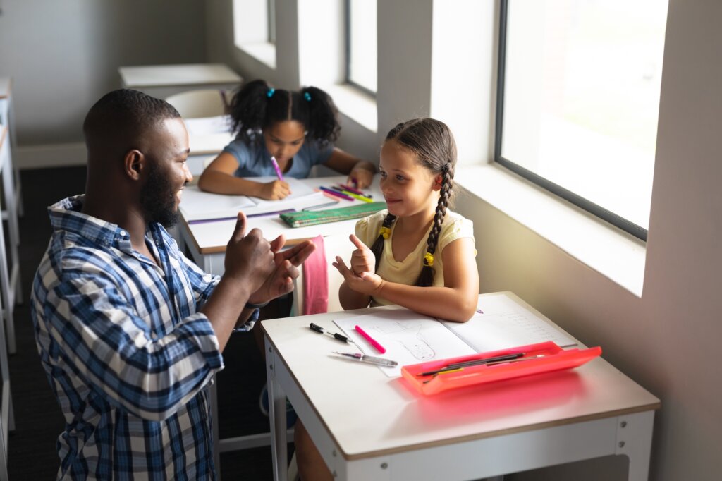 Un enseignant enseigne la langue des signes à un élève en classe
