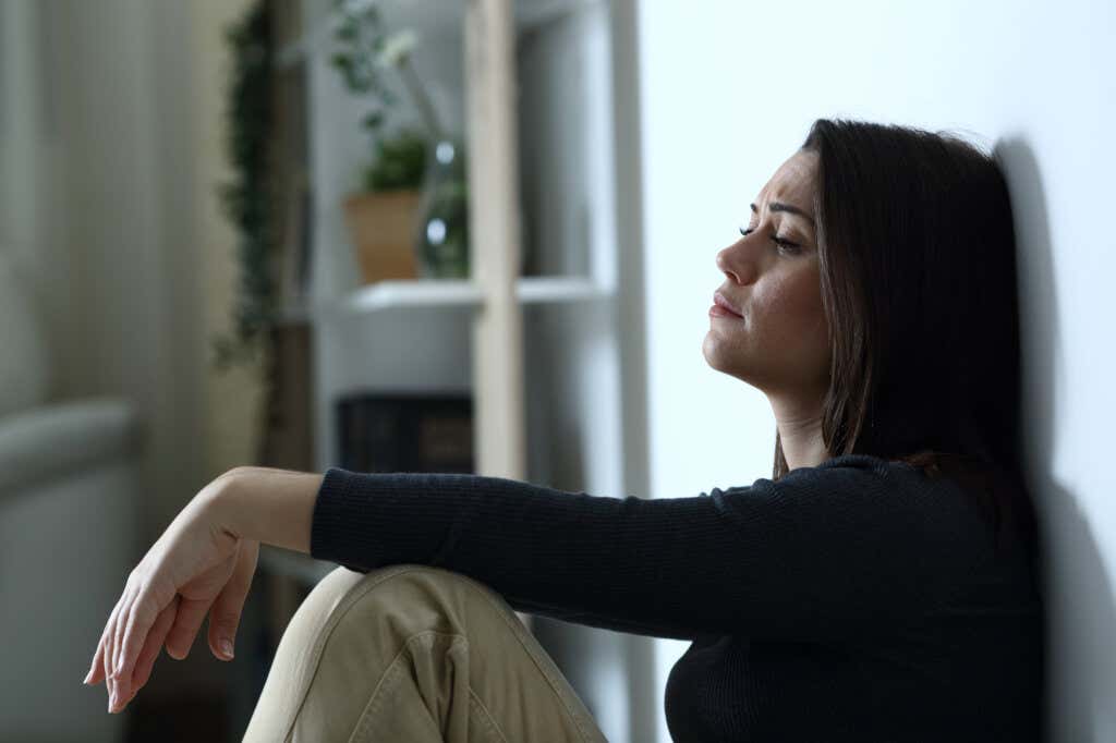 Kobieta z zespołem stresu pourazowego siedzi na podłodze