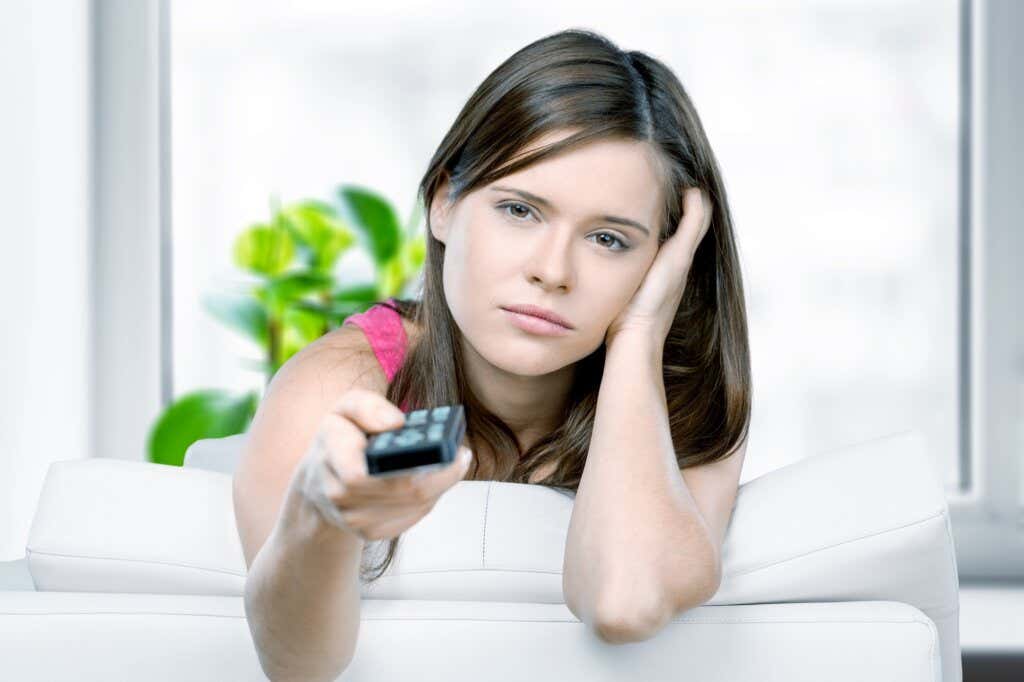 Femme déprimée avec contrôle TV dans une main