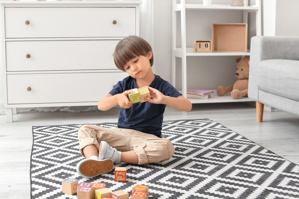 Niño juega con cubos en una habitación