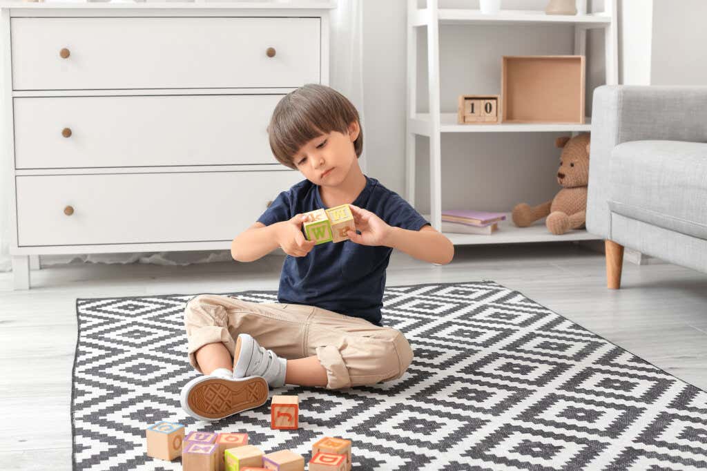 Pojke leker med kuber i ett rum