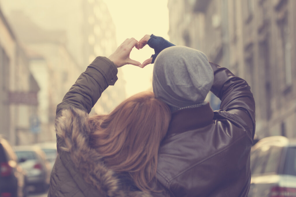 Un couple se donne la main et forme un cœur symbolisant qui nous aimons