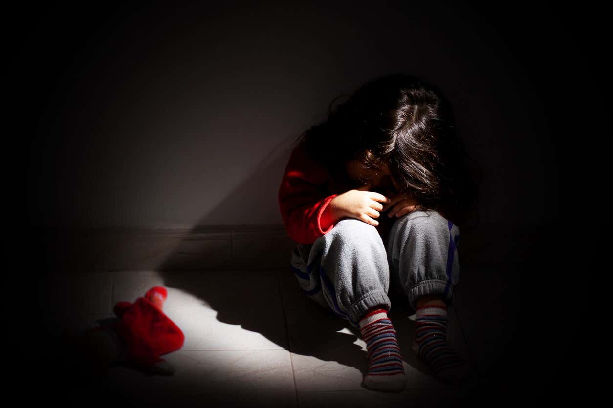Ragazza con le spalle al muro che piange vittima della sindrome da abuso di minori.