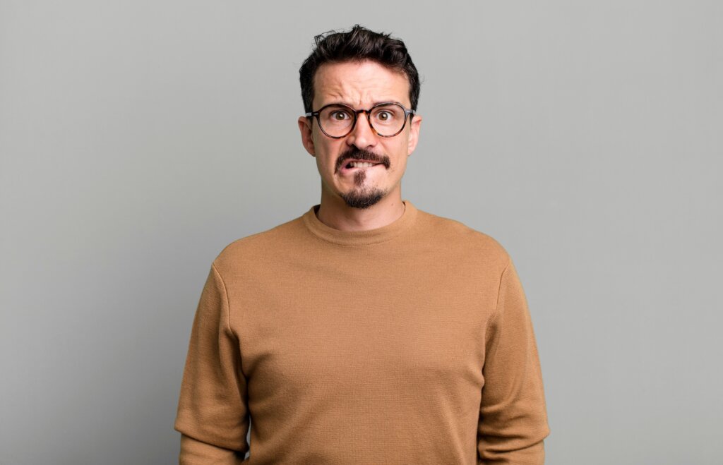 Man biting his lips for suffering from nervous tics