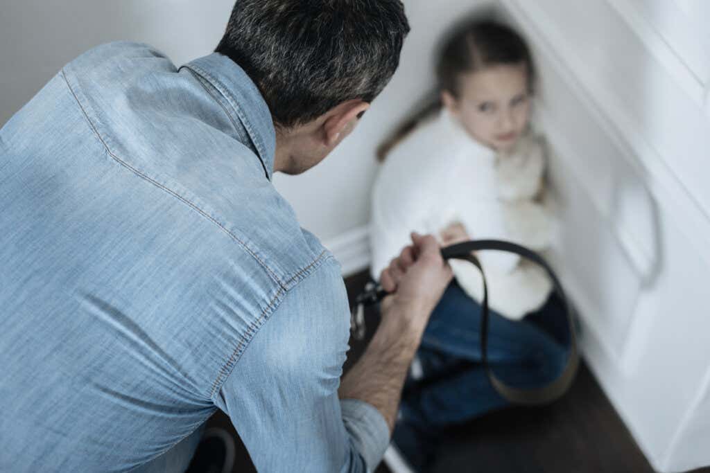 Père avec une ceinture à la main maltraite une fille