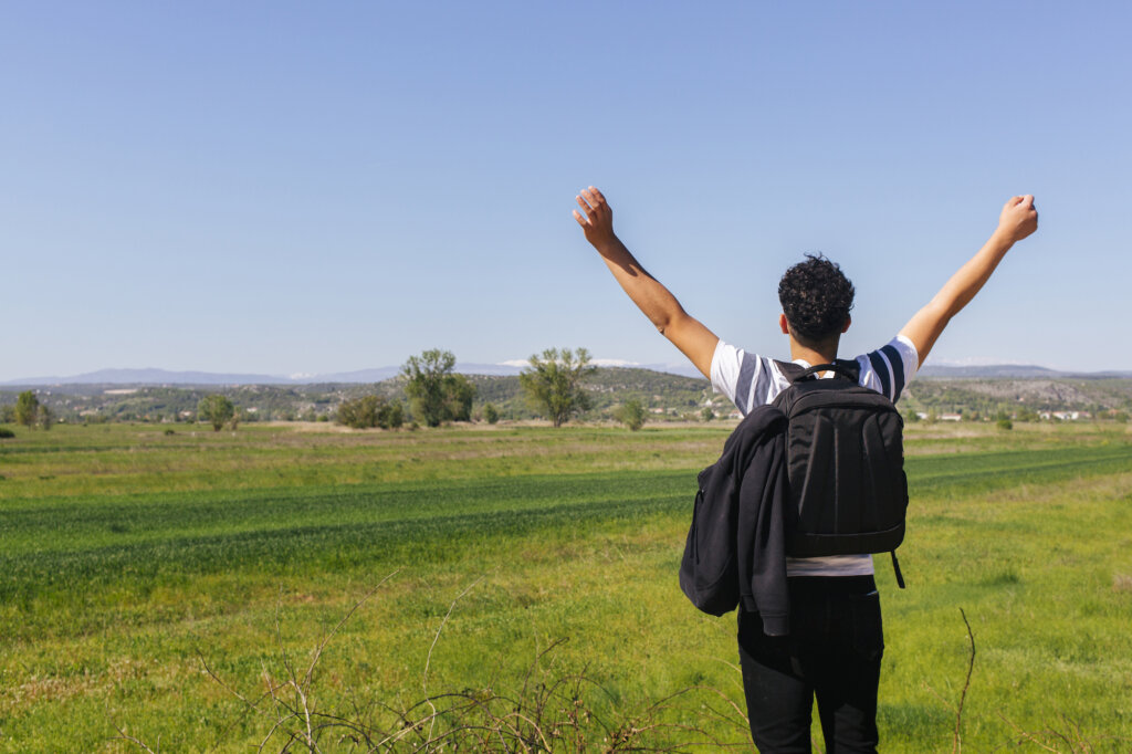 L'homme regarde devant lui sur le terrain et lève les bras