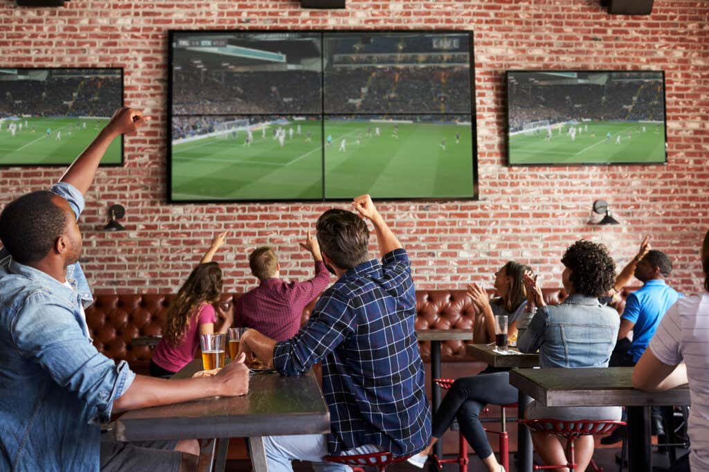 Folk nyter en fotballkamp i en bar