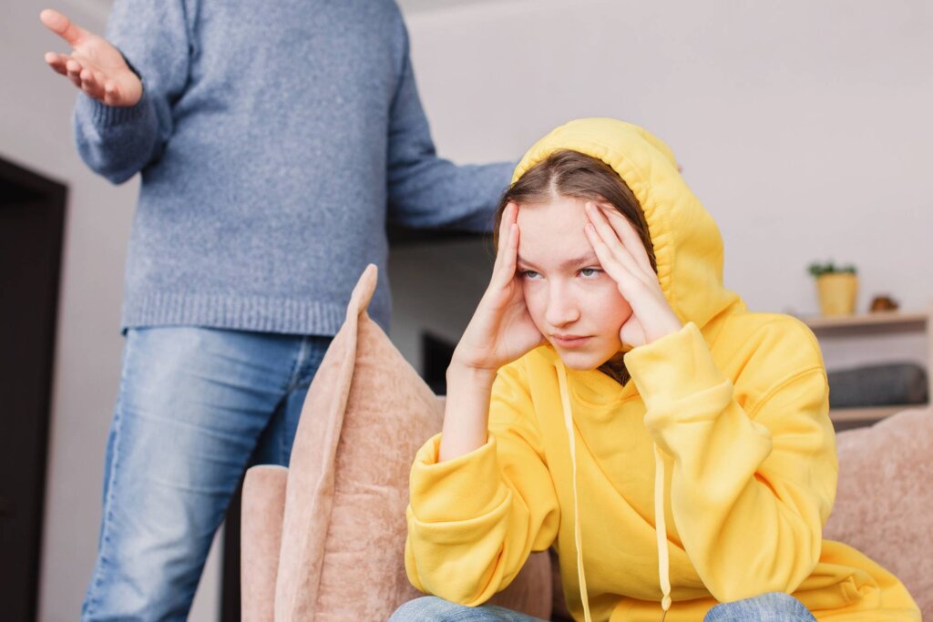 Garota de suéter amarelo está chateada com um adulto e simboliza como lidar com uma família tóxica