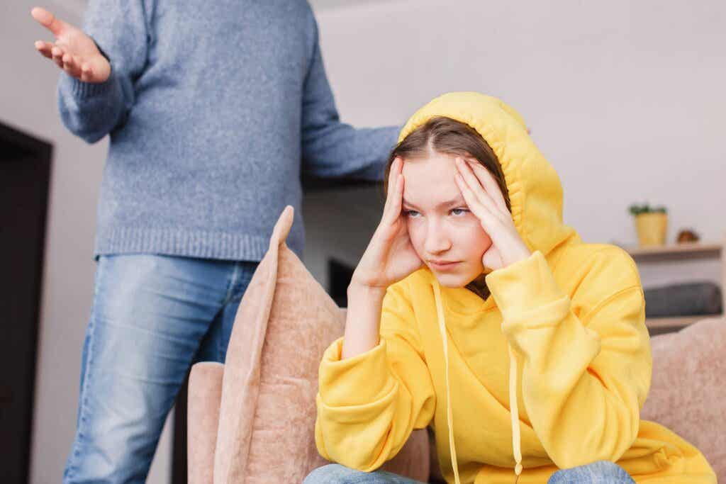 Chica con suéter amarillose muestra molesta con un adulto y simboliza cómo lidiar con una familia tóxica