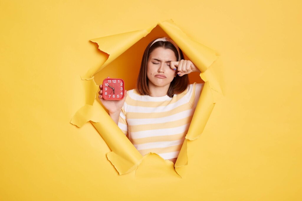 Fille avec horloge se demandant pourquoi tu es toujours en retard