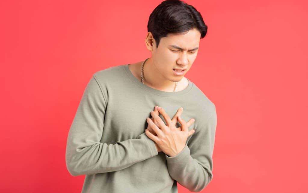 A man putting his hands on his heart when experiencing symptoms of somatic OCD.