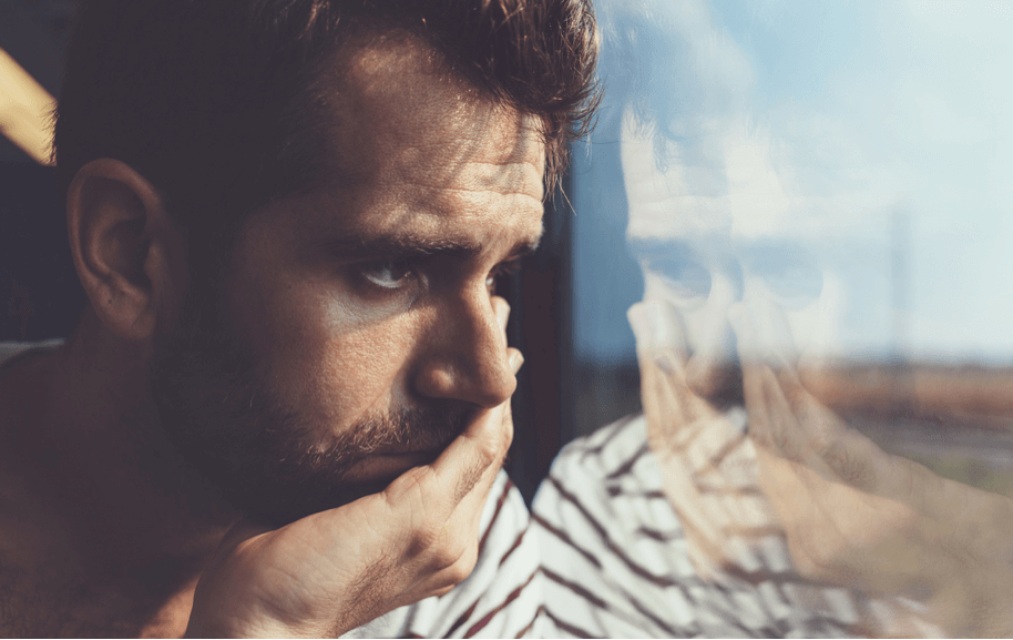 Thoughtful man reflected in a window pane