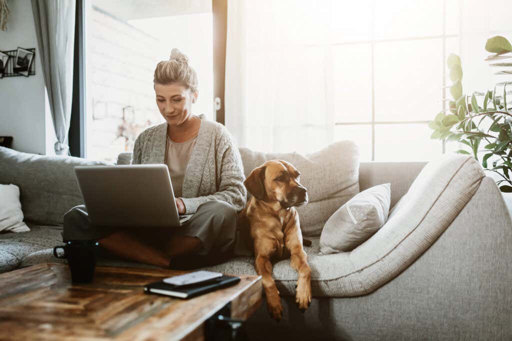 Vrouw werkt thuis met hond naast zich