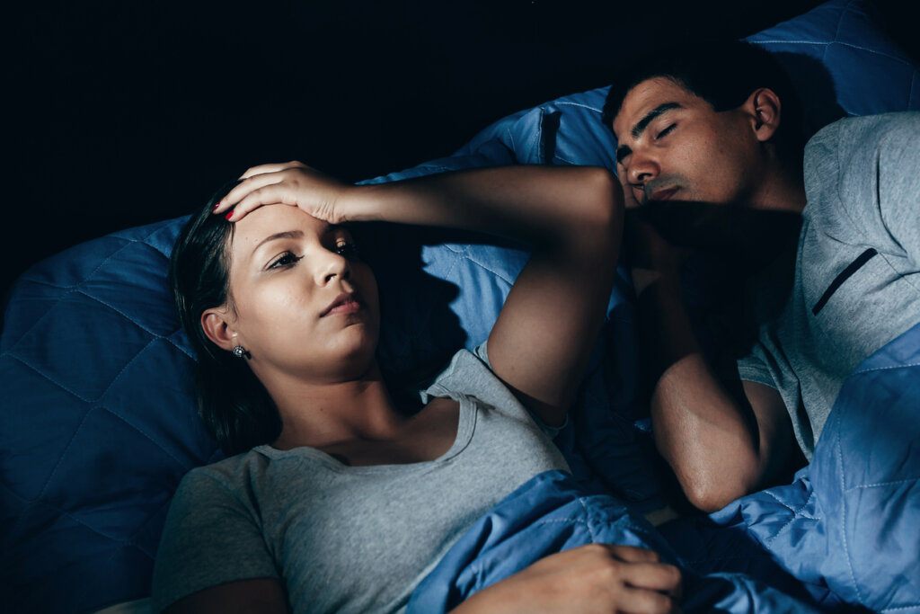 Femme au lit ayant des difficultés à dormir